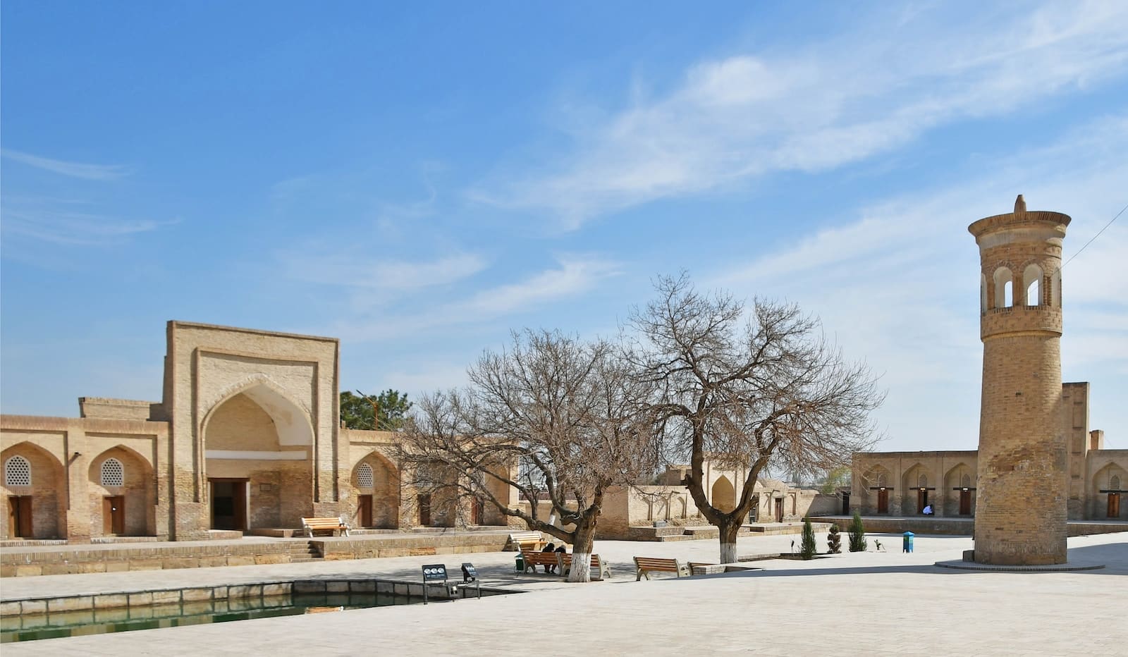 the courtyard of a building with a clock tower in the background